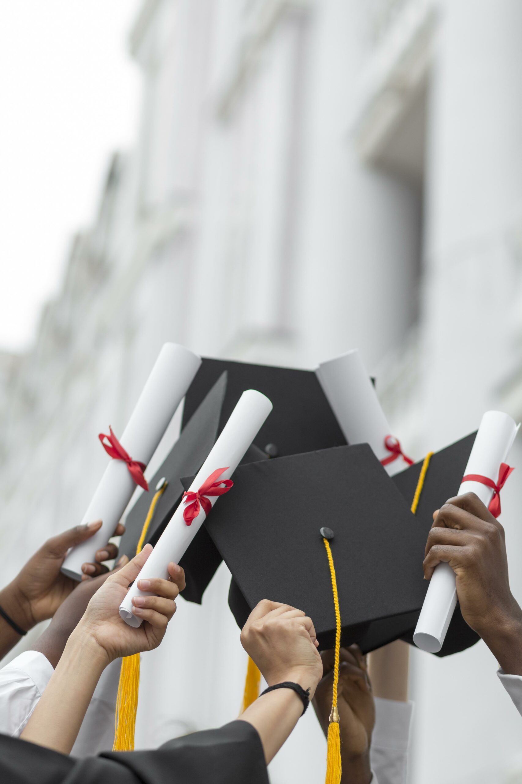 Nahaufnahme-Hände-halten-Diplome-Kappen